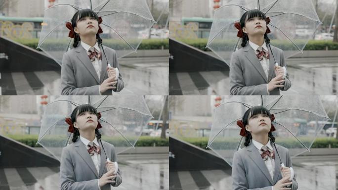 日本女学生身穿校服站在雨中手持透明雨伞
