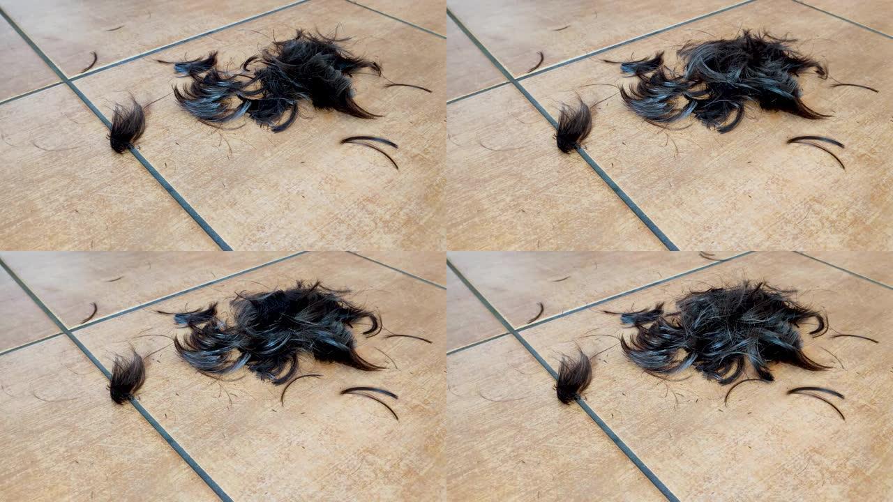 头发脱落。剪头发时头发滴在地板上。剪掉头发。