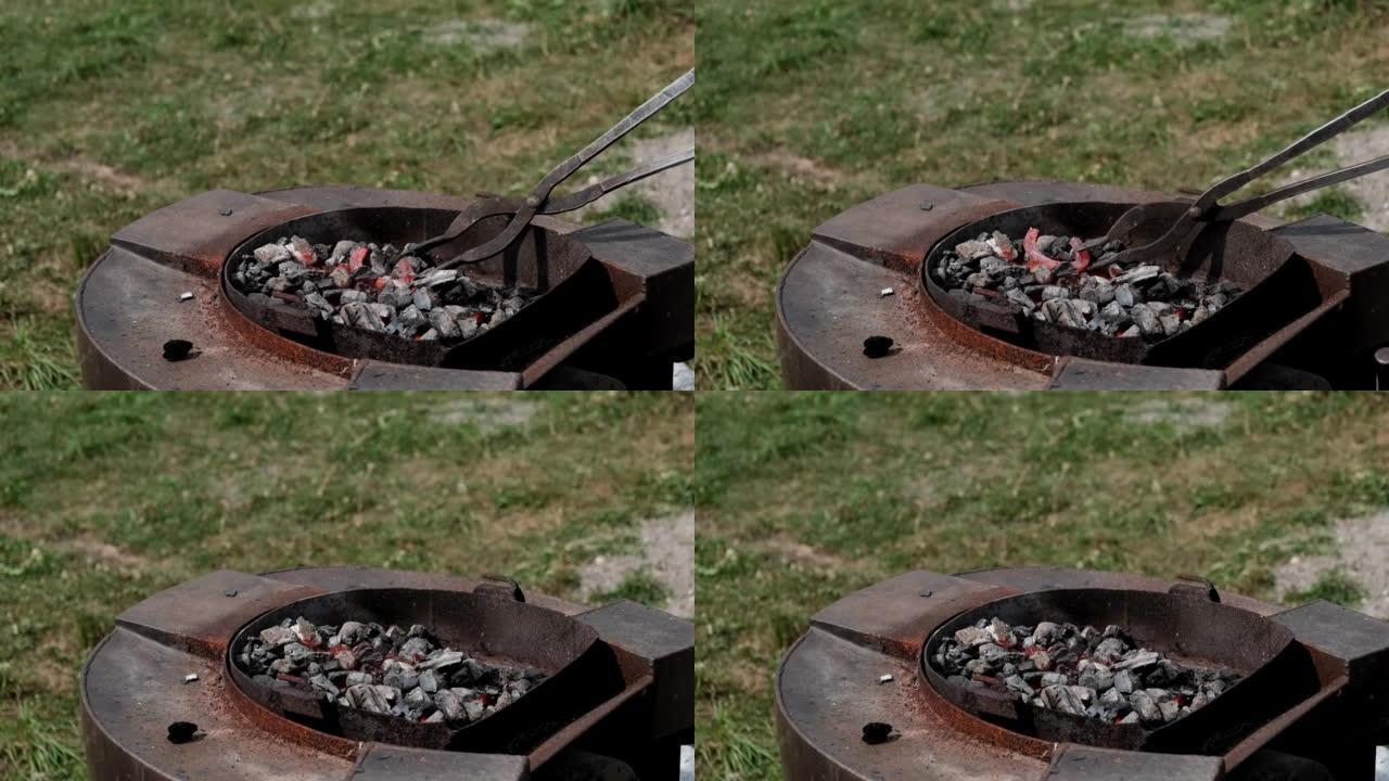 特写铁匠用钳子将熔融的红色金属马蹄铁在火上。锻造工艺。