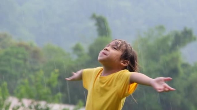 可爱的小女孩玩得开心。孩子们在夏天的雨中玩耍。下雨天在户外玩耍的孩子。