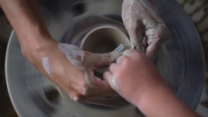 小孩的陶器手工艺艺术课，大人的帮助，教小孩陶器。妈妈和女儿从事粘土成型，儿童在艺术和手工艺方面的发展
