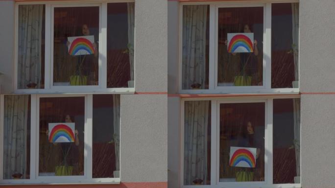 男孩在家里的窗户里拿着彩虹。彩绘标志，吸引眼球