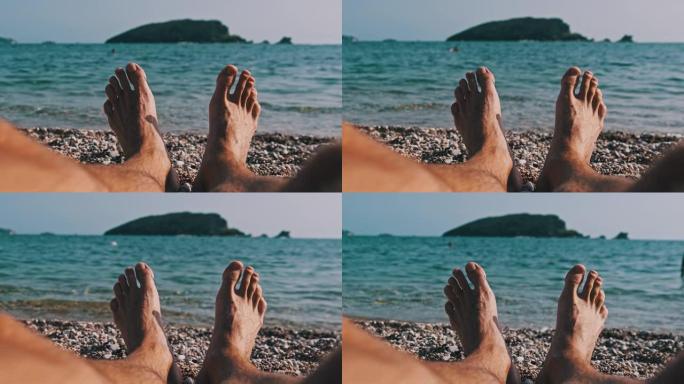 POV年轻男性赤脚在卵石海滩的海洋景观
