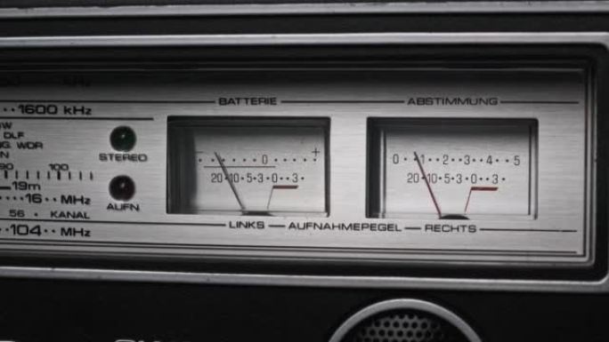 银色立体声录音机上的模拟VU仪表，箭头指示器