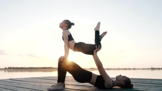 两个小女孩做双人杂技瑜伽，一起做体操杂技练习