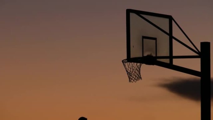 篮球比赛剪影的箍和网。球员在篮球场上比赛。