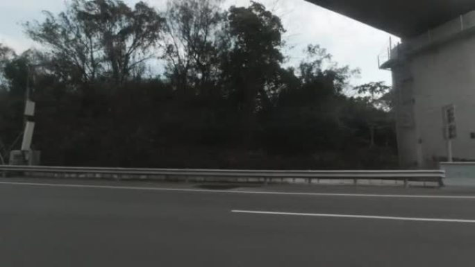 从一辆行驶中的汽车，经过高速公路一侧的隔音板。