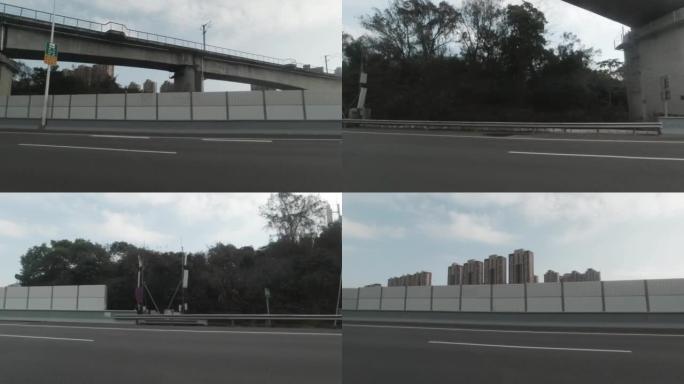 从一辆行驶中的汽车，经过高速公路一侧的隔音板。
