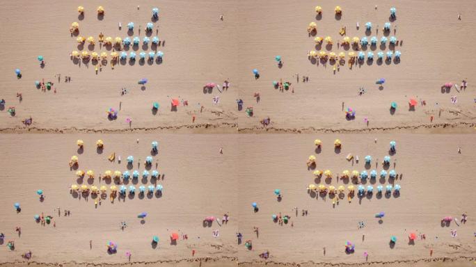 在美国佛罗里达州迈阿密的南海滩，色彩丰富的沙滩伞和人们享受夏天的俯视图