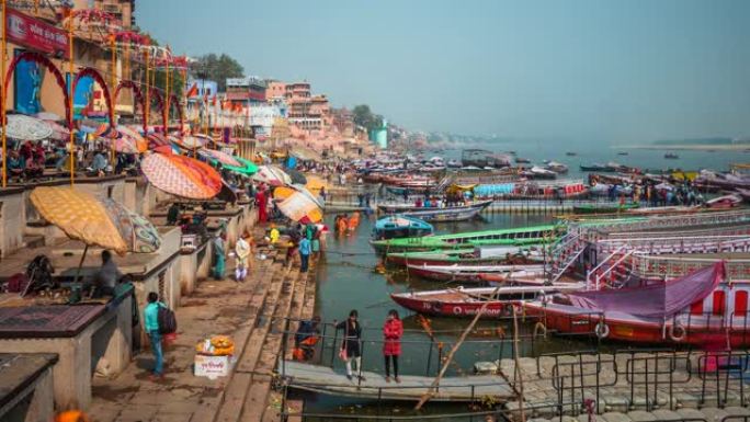 印度瓦拉纳西，瓦拉纳西城市景观的延时视图，显示了色彩丰富的船只和印度教徒在神圣的恒河中沐浴