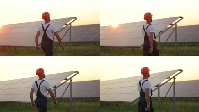 穿着制服的人手里拿着手机走在太阳能站上。