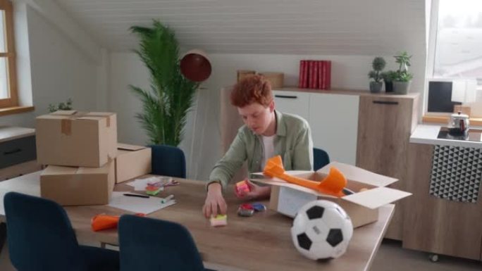 英俊的红发少年为慈善捐赠准备玩具