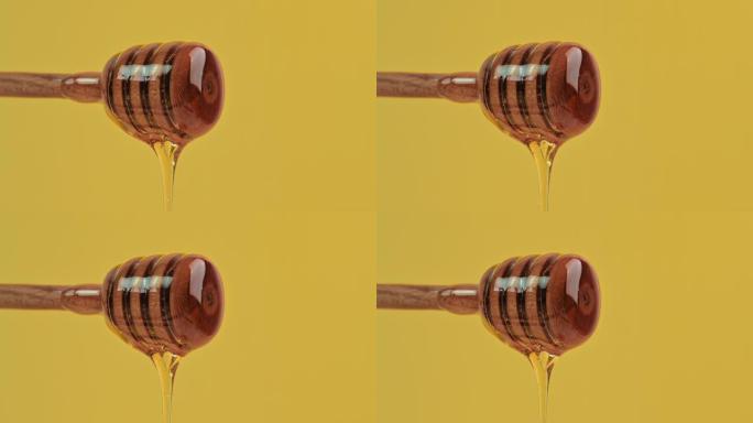 健康食品概念。美味的甜蜜糖液体蜂蜜从黄色背景上的木勺流下来。有机健康蜂蜜，维生素，甜食。从勺子里滴下