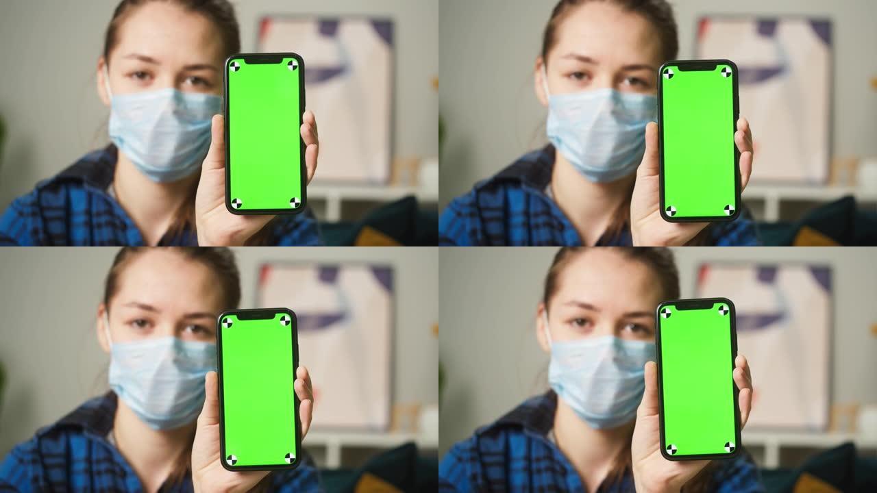 妇女戴着医用口罩，显示带色度绿屏的手机，带二维码的疫苗接种护照，移动设备上的国际冠状病毒covid 