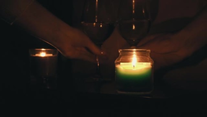 晚上，男孩和女孩在床边的烛光下喝酒
