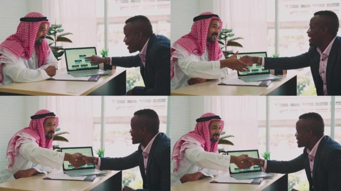 中东商人和非洲商人开会并使用笔记本电脑在办公室工作