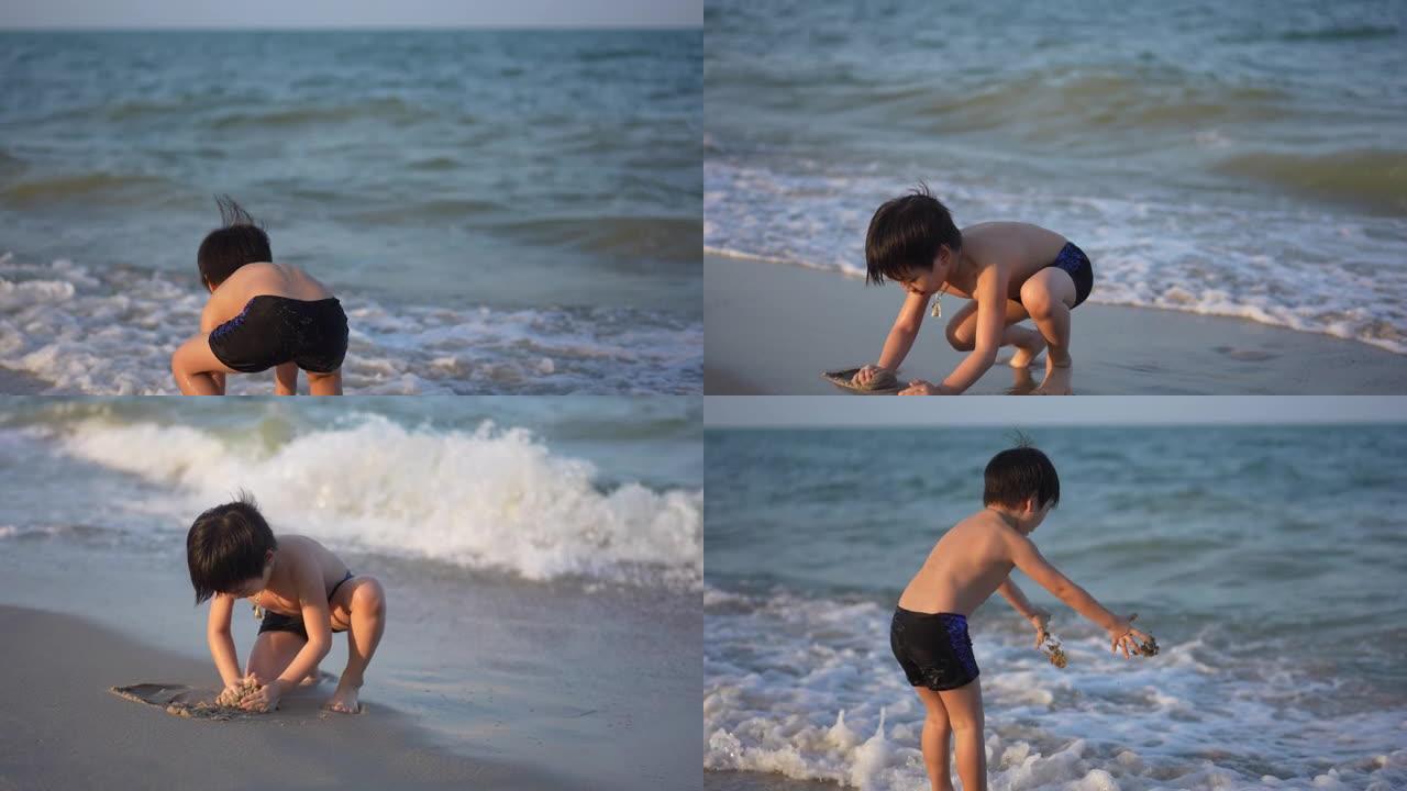 日落时，亚洲男孩在海滩上享受和玩海和沙滩