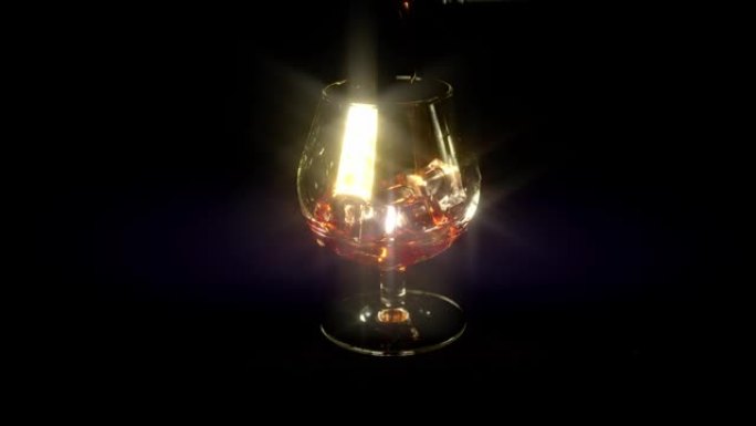 将红酒或威士忌倒入带有高光的黑色背景的玻璃杯中的过程。酒保准确倒入酒精饮料玻璃，黑色背景上有冰块