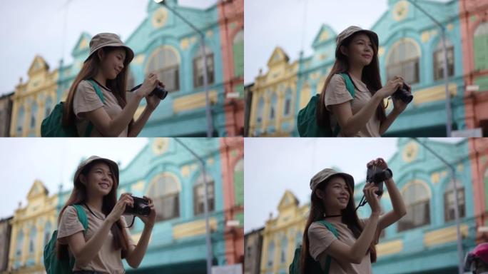 亚洲年轻女性背包客用相机到摄影的地方旅行时带着快乐的情感表达，在生活方式假期夏天独自旅行。