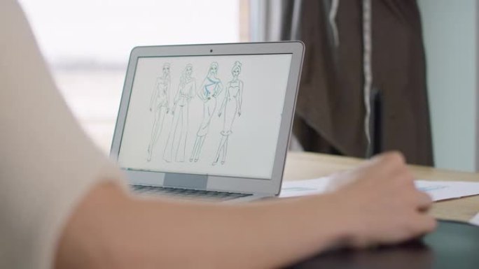 白人成年女性使用笔记本电脑和移动应用程序并设计连衣裙。用8k的红氦相机拍摄