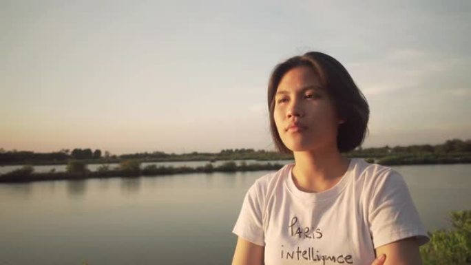 亚洲女人仰望日落背景的天空
