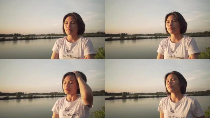 亚洲女人仰望日落背景的天空
