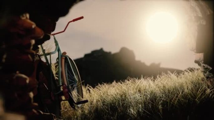 黄昏时分在草地上骑自行车。一辆自行车站在山洞的入口处。太阳落山时休息。
