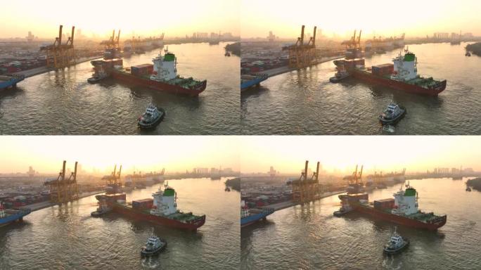 在泰国曼谷的日出场景中，空中无人机拍摄了码头上的一艘货船港口，吊臂下降到适当位置以卸下集装箱