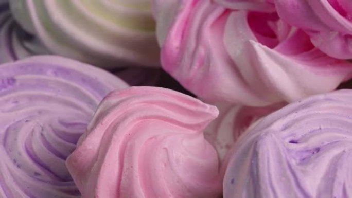 甜蛋白酥皮旋转特写。法国糖果，蛋白质和糖饼干粉色和紫色。儿童生日糖果的节日背景。慢动作就绪，4k，5