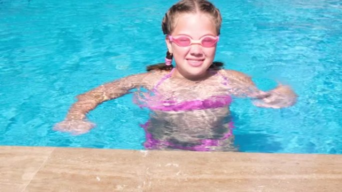 勇女孩戴着水杯，在游泳池里潜水。慢动作