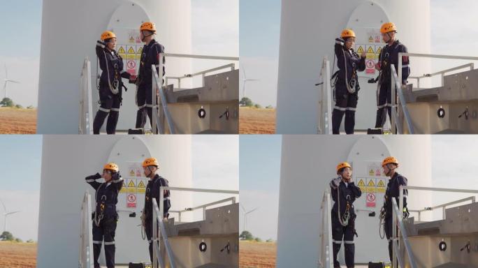 两名亚洲工程师在统一检查工程师的准备和进度检查在泰国风电场中的风力涡轮机的安全性。
