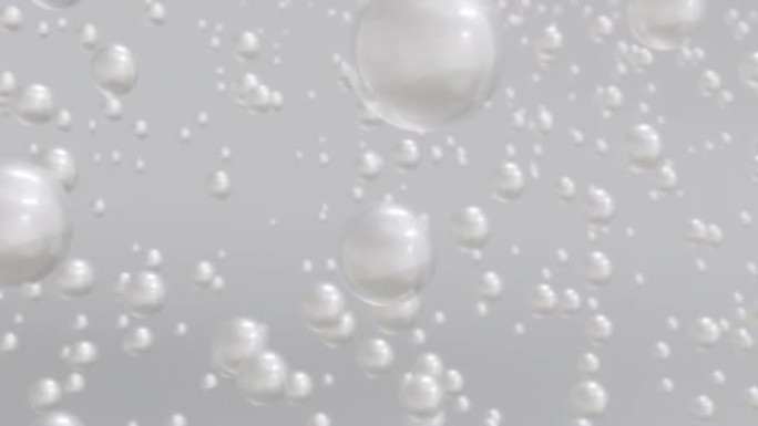 在浅色背景上升起的水中各种白色珍珠气泡的宏观拍摄。
