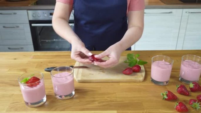 切草莓来装饰甜点。在家制作健康的自制草莓布丁