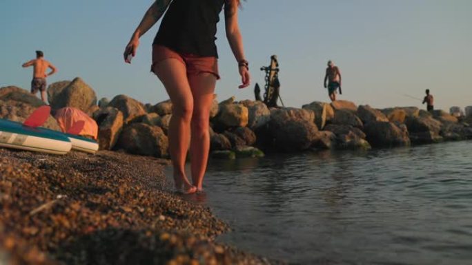 一个晒黑的女人，脚踩在海边。腿特写。慢动作。马蹄内翻足和关节炎的概念