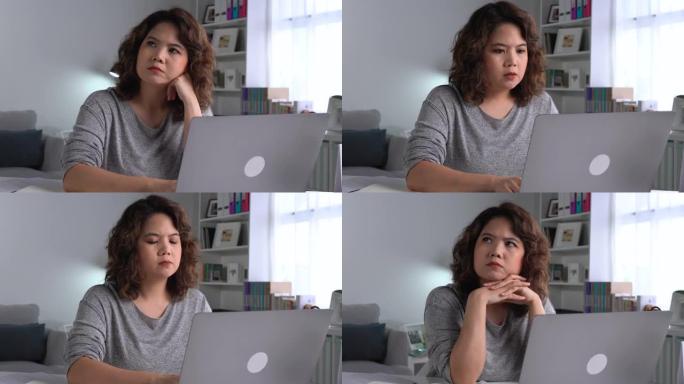 感到疲倦和压力。年轻的亚洲妇女坐在办公室里用笔记本电脑工作时，思想深处疲惫不堪。