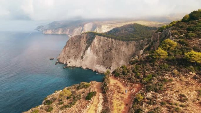 希腊扎金索斯爱奥尼亚海海岸的空中无人机视图。游客走在岩石悬崖上，植被，碧水。日落