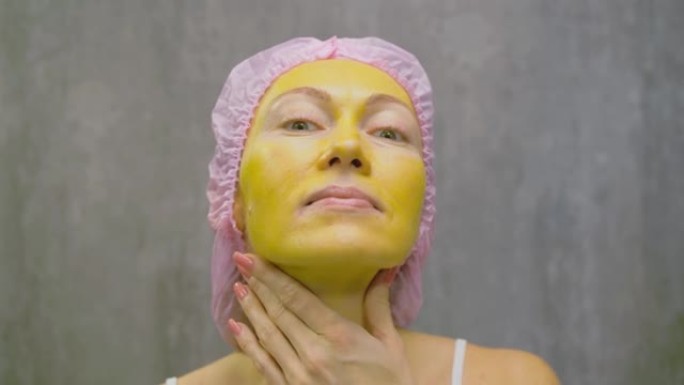 年轻漂亮女人脸上的皮肤护理程序。美容院，面部脱皮黄金海藻酸盐面膜，视黄醇处理，果酸