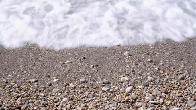 白色鹅卵石海滩背景下的泡沫透明海浪