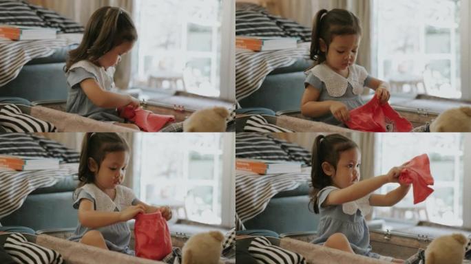 女孩坐在手提箱里，享受折叠布包装。
