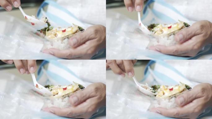 双手拿着白勺，舀米饭。