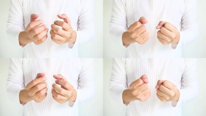 男人移动手指和手腕，他在手腕和手指上锻炼。由于手掌的肌腱受伤，他的手和手指麻木。