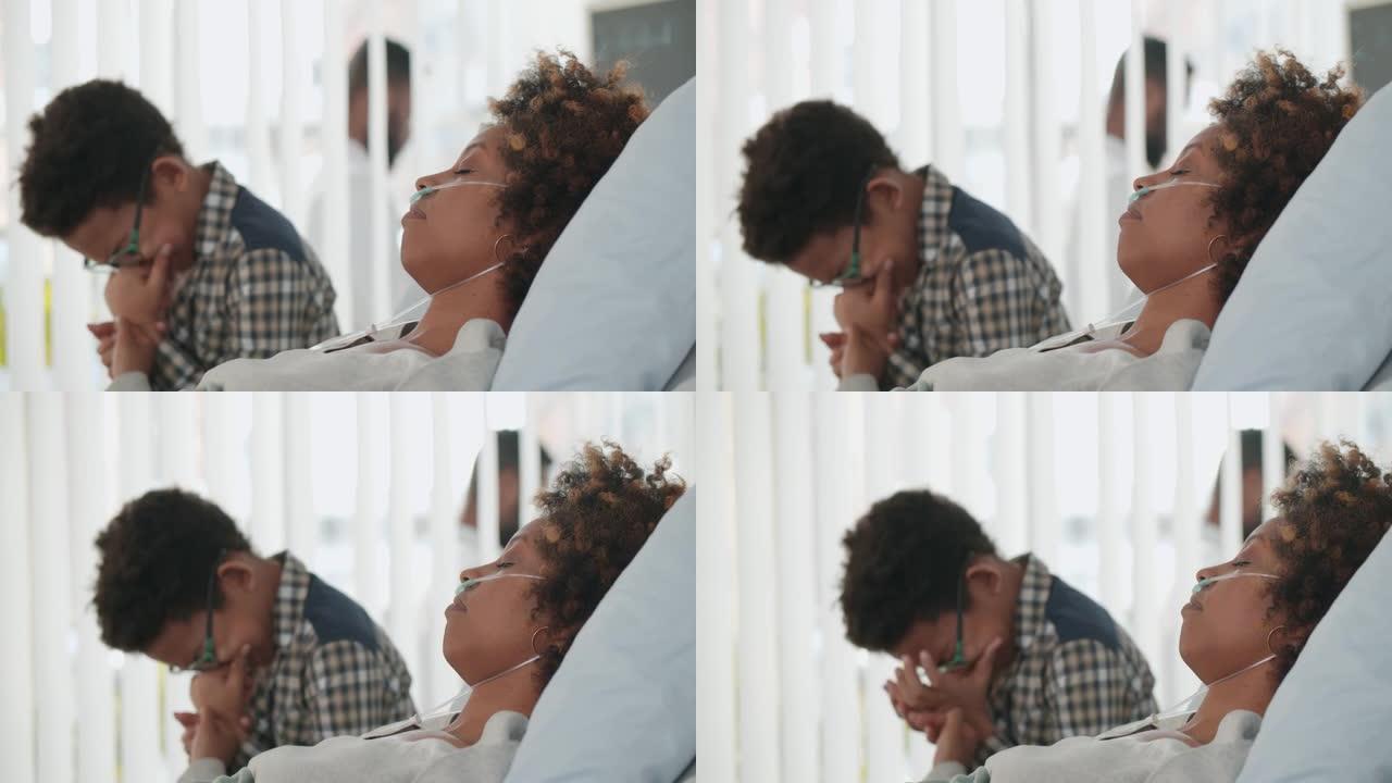 青春期的非洲裔美国男孩坐在医院病房里，抱着生病的母亲哭泣