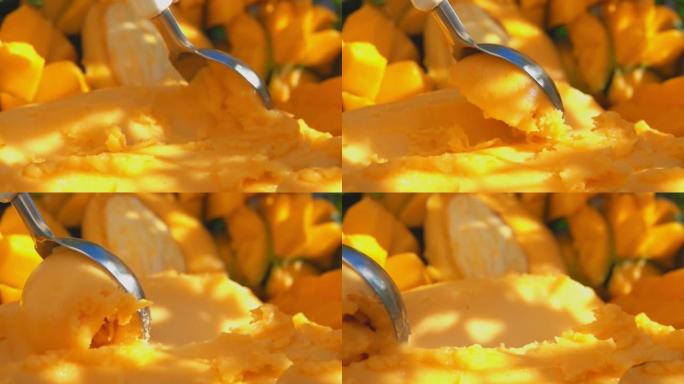 勺子的特写慢慢舀冷冻黄色芒果冰淇淋冰淇淋
