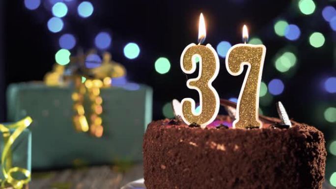 生日蛋糕上有37号蜡烛，明亮的节日背景上闪烁着灯光，打火机上的火，吹灭蜡烛三十七年。