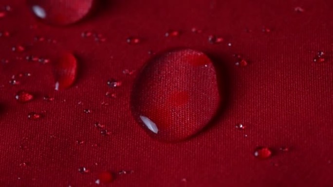 防水纺织布概念。雨水，水滴溅到外套上，但防水可以避免潮湿。
