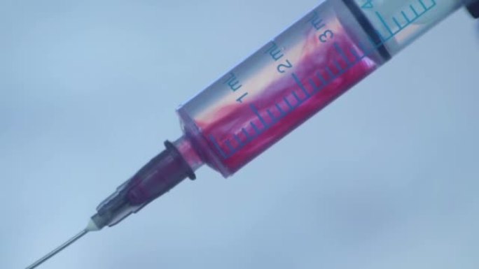 注射器蓝色背景下注射液体的特写。用药药物针头注射器流感疫苗