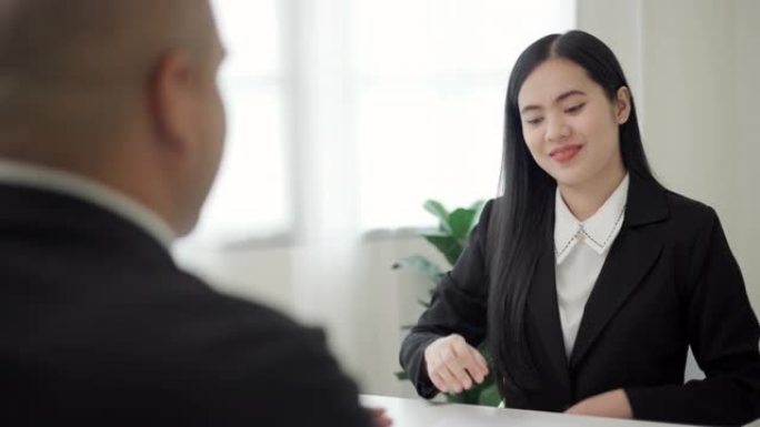 聪明的亚洲女人在求职面试前握手问候人力资源人员。快乐的女寻求者或保险经纪人提出商业交易。女商人发送简