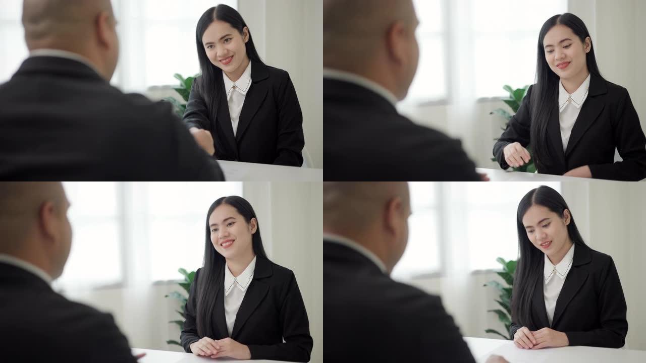 聪明的亚洲女人在求职面试前握手问候人力资源人员。快乐的女寻求者或保险经纪人提出商业交易。女商人发送简