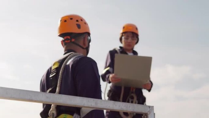 两名亚洲工程师在统一检查工程师的准备和进度检查在泰国风电场中的风力涡轮机的安全性。