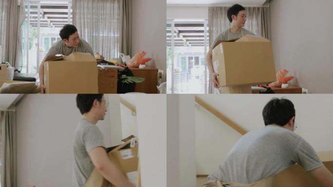 亚洲男子搬到新房子时拿着盒子